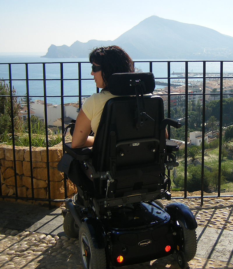 Mujer en silla de ruedas observando el mar desde un mirador