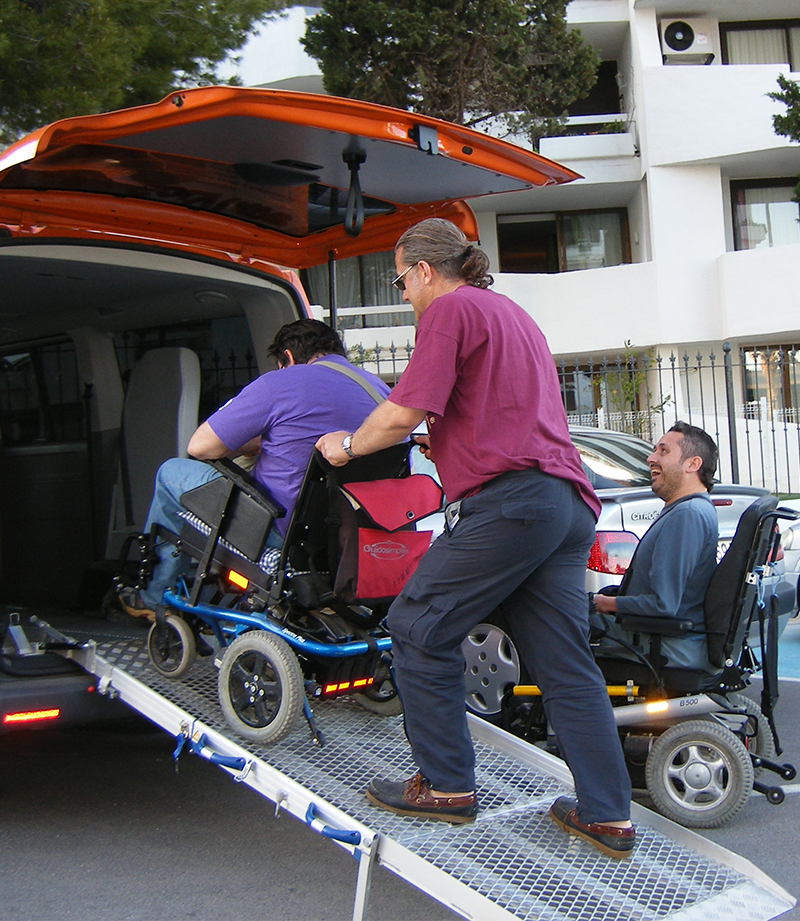 Hombre en silla de ruedas subiendo por la rampa de una furgoneta adaptada